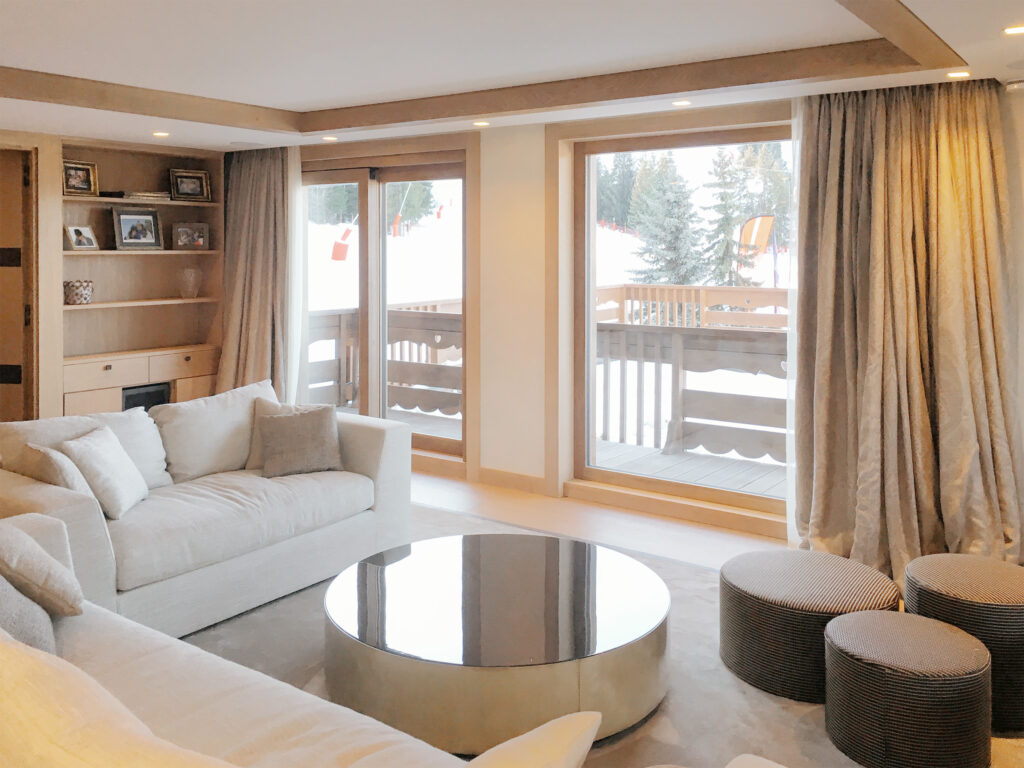 Le salon de cet appartement donnant sur la piste de ski est un espace contemporain avec des détail en bois qui lui donne un aspect chaleureux.